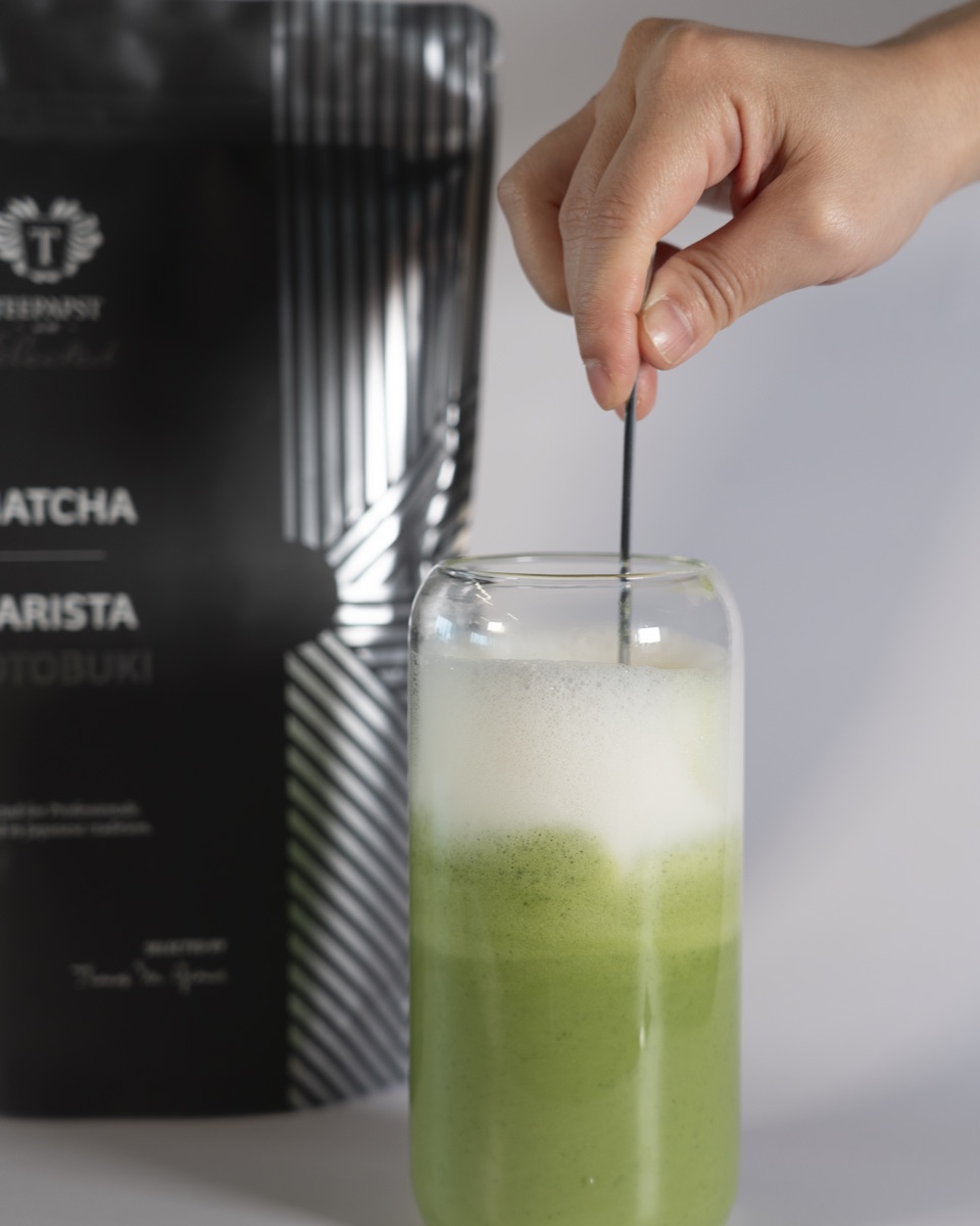 Matcha Latte aus Kotobuki im Glas, daneben der 500-g-Beutel