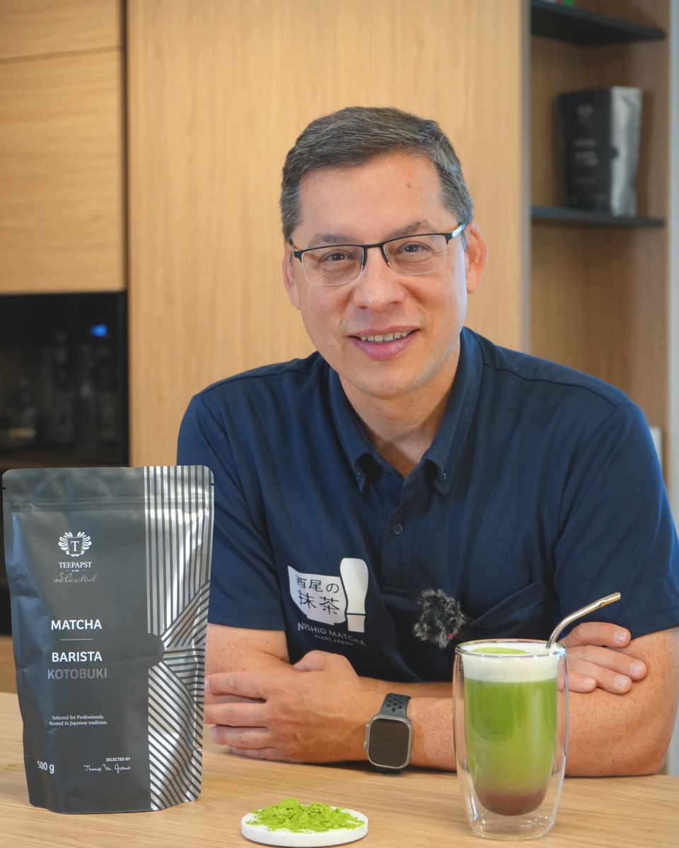 Thomas M. Grömer, der Teepapst, mit dem Beutel Bio-Matcha Barista Kotobuki, einer Schale Matcha-Pulver und einem fertigen Matcha Latte